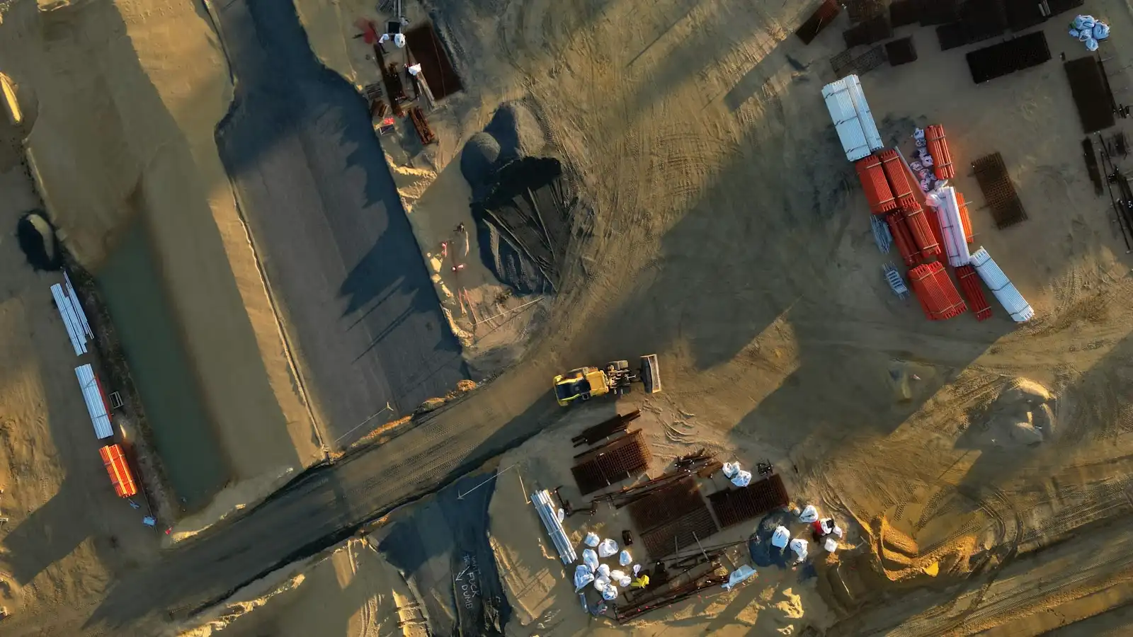 Aerial view of a construction site with multiple equipment and trucks