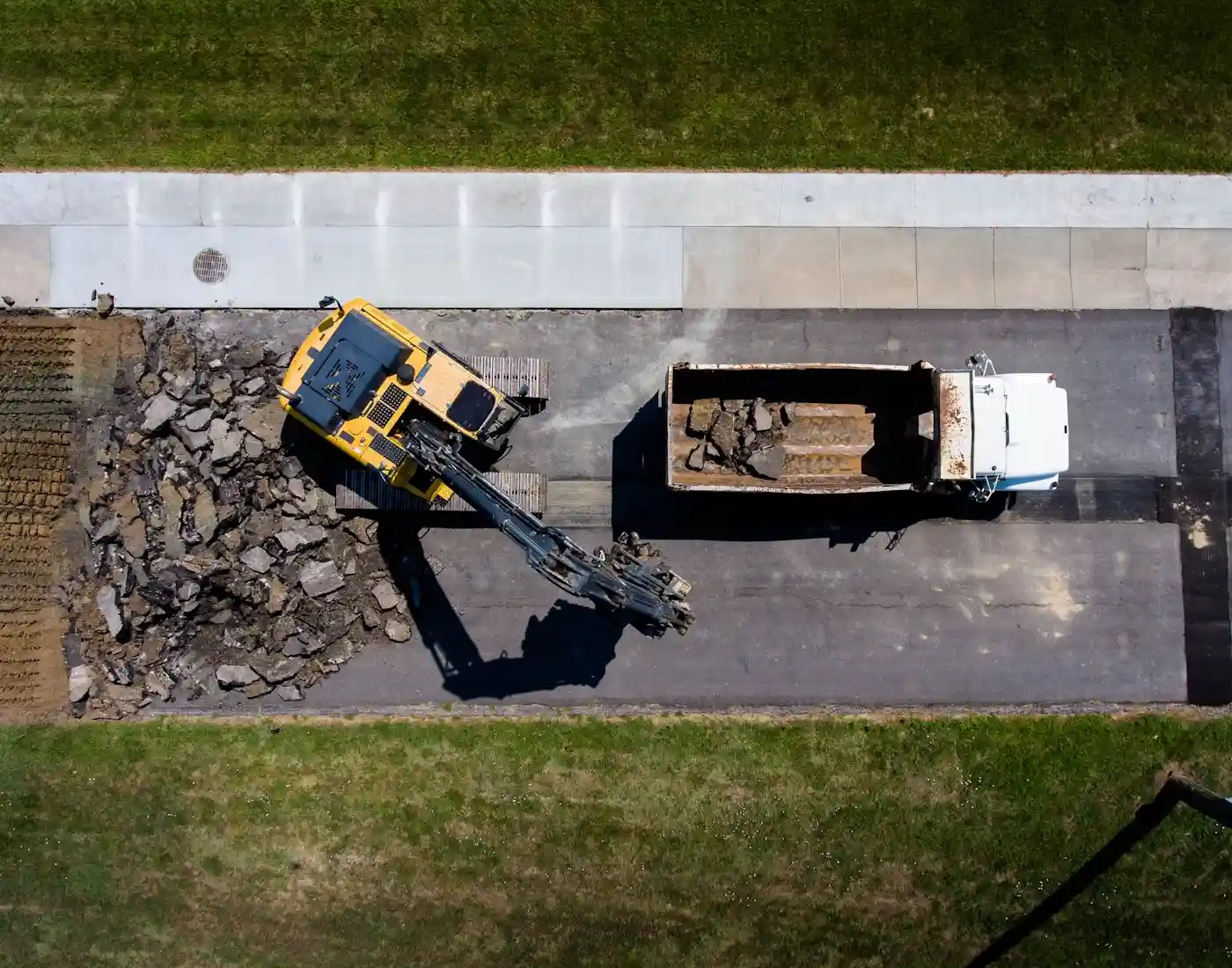 Aerial view of heavy equipment and a dump truck at a road construction site